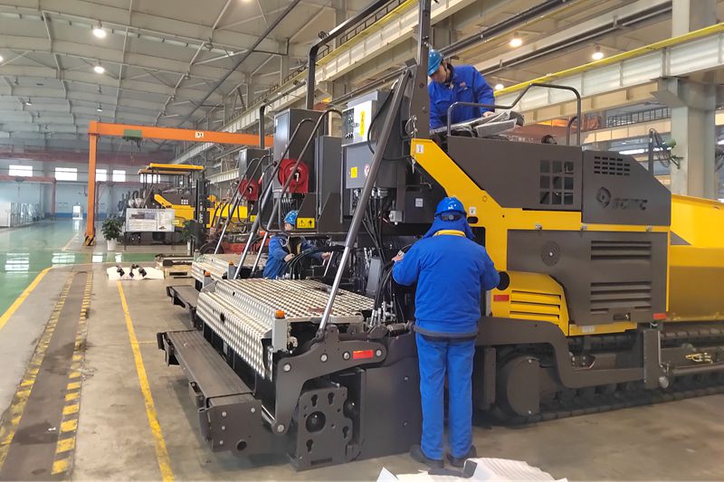 1、工人們抓緊時間總裝即將出口的瀝青混凝土攤鋪機.jpg